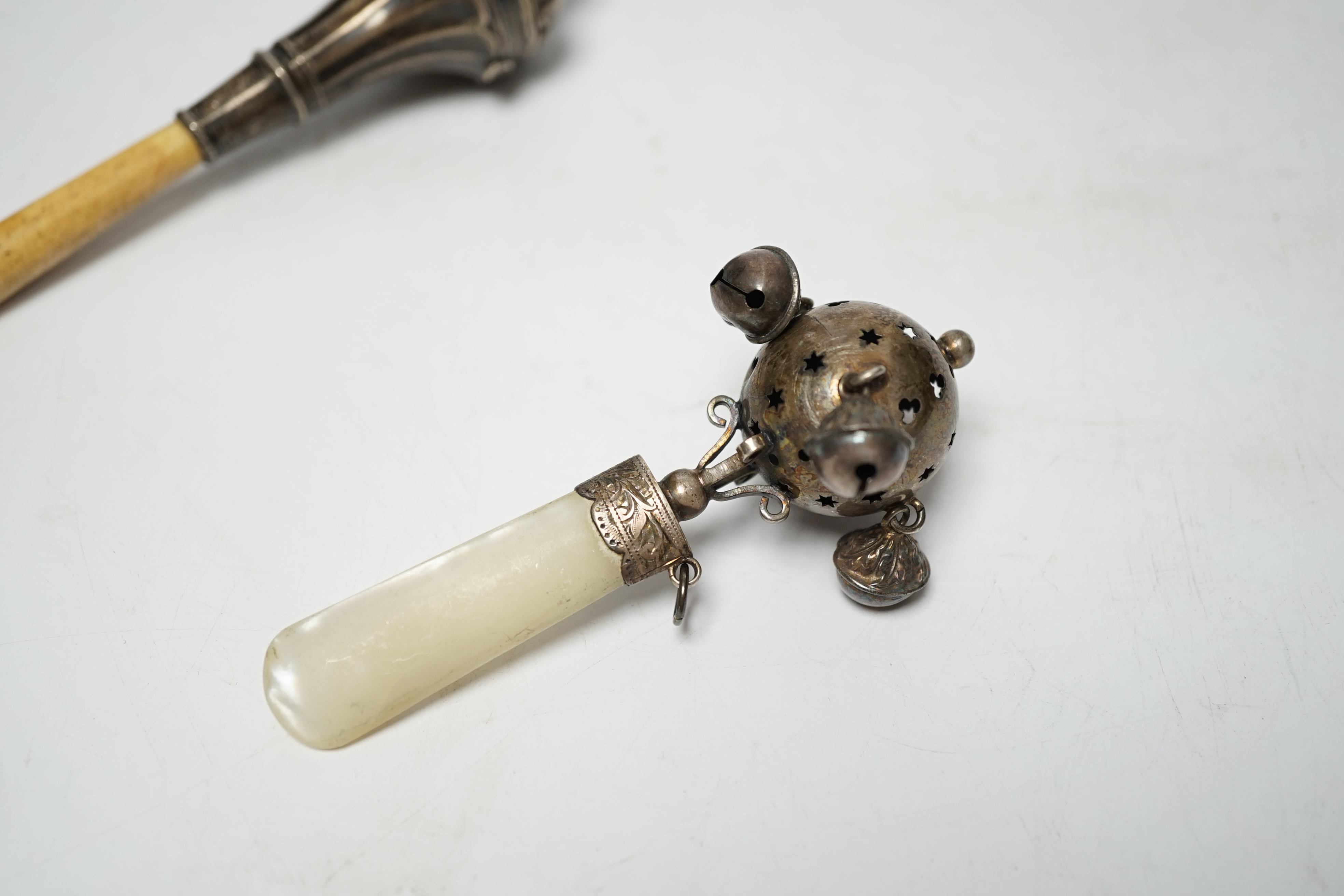 Two baby's silver rattles, Edwardian with mother of pearl handle, Birmingham, 1908, 10cm and later George V with bone handle and lacking bells.